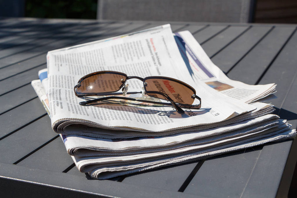 Pile of newspapers and sunglasses - Photo, Image