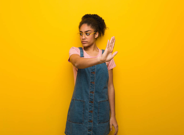 Joven negro afroamericano chica con ojos azules poniendo la mano en frente
 - Foto, imagen