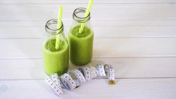 gezonde groene en veganistische cocktails met centimeter tape op witte houten tafel - Video