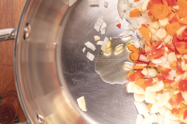 Zanahorias picadas y cortadas en cubitos, cebollas, ajo y aceite para un salteado
 - Foto, imagen