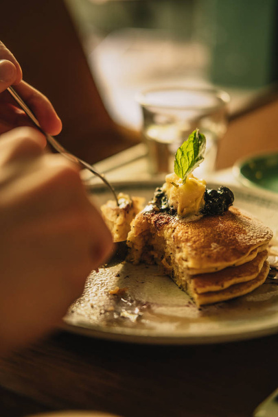 American ricotta pancakes stack with honey and cream, wooden table. Warm light colored image filter effect. Food photography concept - Foto, imagen