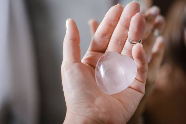 Woman holds rose quartz heart crystal - 写真・画像