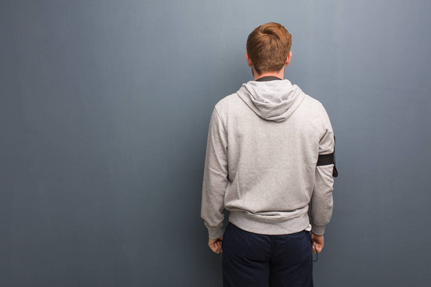 Young fitness redhead man from behind, looking back - 写真・画像