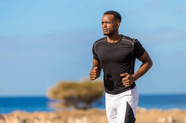 Μαύρο αφρικανικό αμερικάνικο νέος άνθρωπος τρέξιμο εξωτερική - Φωτογραφία, εικόνα