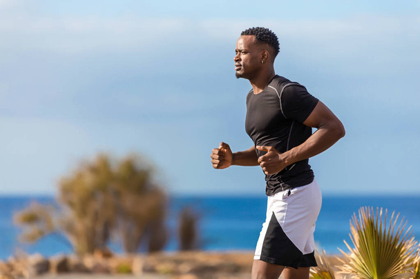 Black african american young man running outdoor - Foto, afbeelding