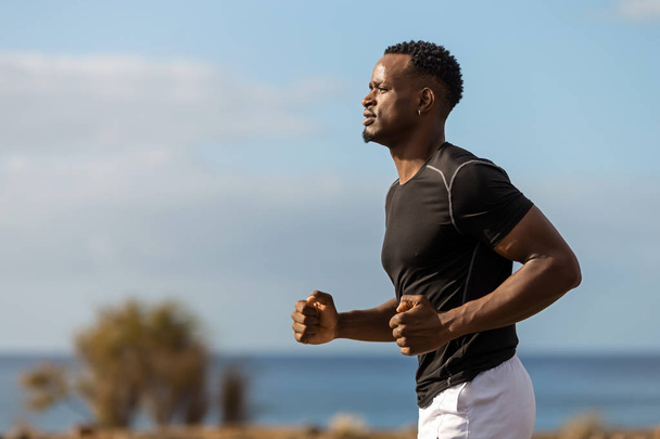 Black african american young man running outdoor - Fotó, kép