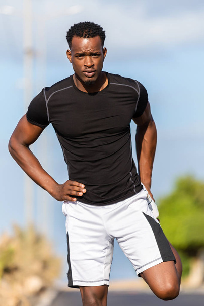 Black african american young man stretching after outdoor joggin - Foto, immagini