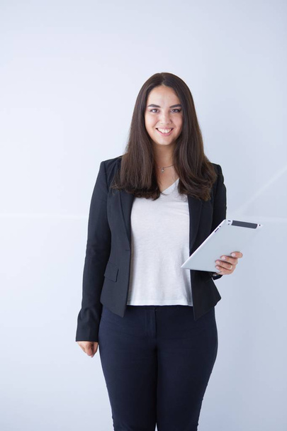 Portrait of smiling young business woman with digital tablet in her hands. - Foto, imagen