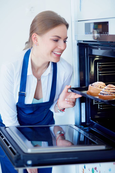 Woman cook holding plate with homemade baked goods - Foto, Bild