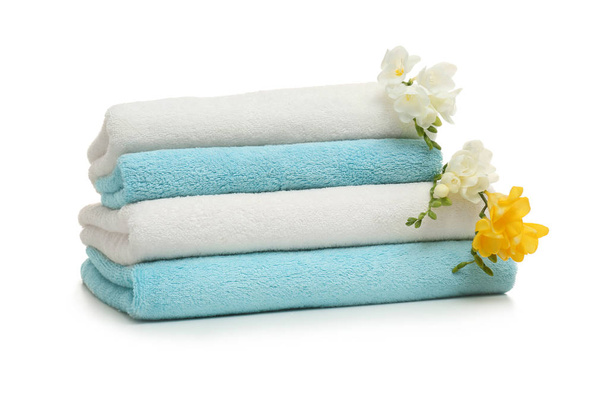 Stack of clean folded towels with flowers on white background - Foto, Imagem