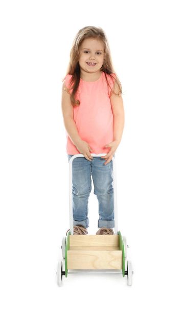 Pretty little girl with wooden cart against white background - Foto, afbeelding
