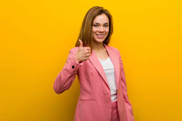 Young fashion business woman smiling and raising thumb up - Fotó, kép