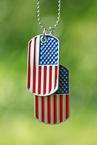 Amerikan lippu koira tunnisteet roikkuu ulkona
 - Valokuva, kuva