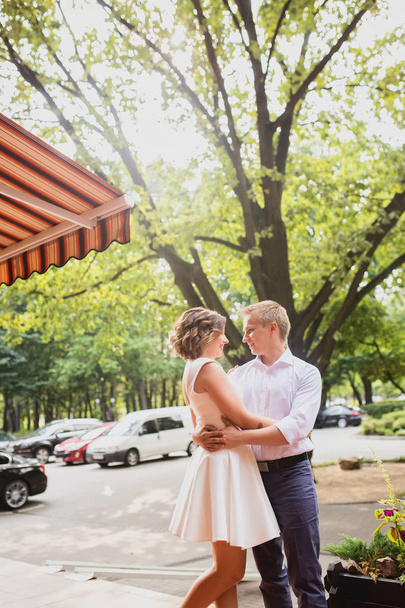 attractive young bride and groom walking near cafe outdoors background - Photo, image