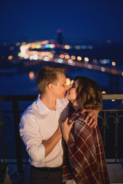 sorprendente pareja joven de amantes de pie sobre el puente en la noche vista de fondo de la ciudad. - Foto, imagen