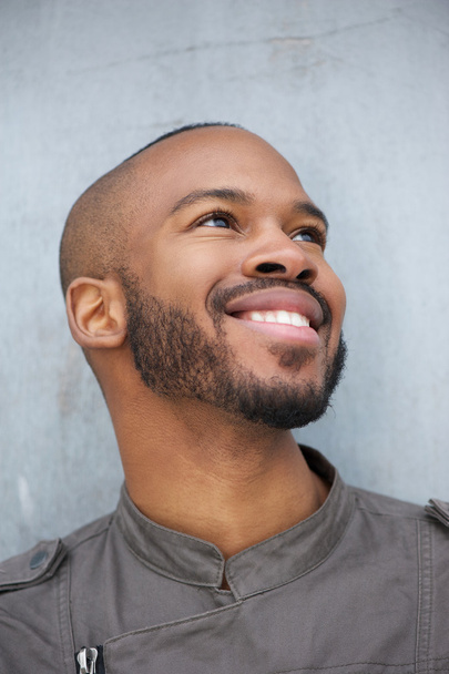 Портрет счастливого молодого африканского американца, улыбающегося
 - Фото, изображение