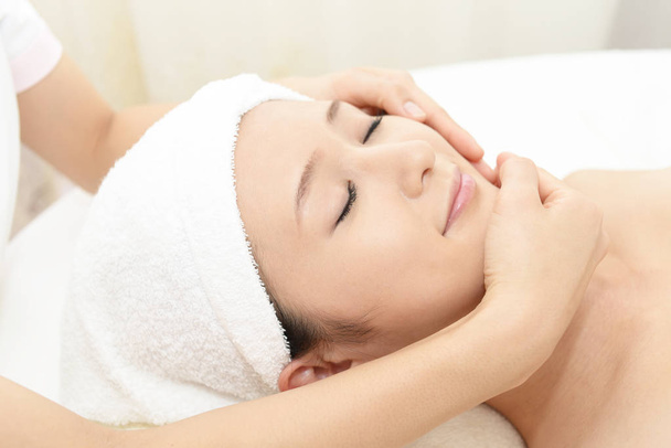 Belle jeune femme recevant un massage facial - Photo, image