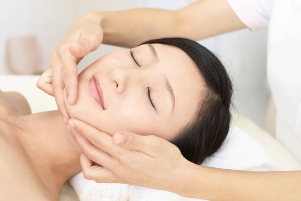 Belle jeune femme recevant un massage facial - Photo, image