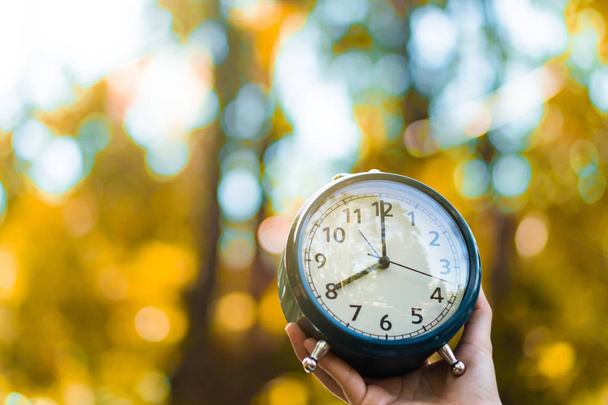 Selective focus of alarm clock with nature background. - Photo, Image