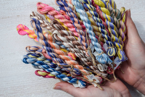 Braided threads for embroidery in female hands - Photo, Image