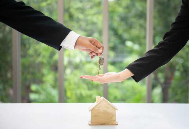 Business Man χέρι δώσει τα κλειδιά του σπιτιού για την επιχειρηματική γυναίκα χέρι με - Φωτογραφία, εικόνα