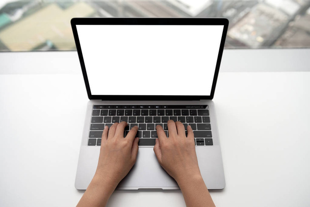 Top view of woman hand is typing on laptop keyboard with mockup  - 写真・画像