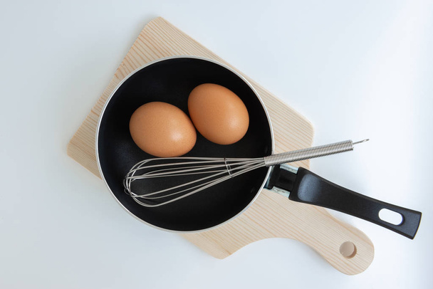 Pan met ei en roestvrijstalen Eier klop en hakken op de w - Foto, afbeelding