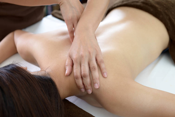 Woman receives body massage at spa salon - Foto, afbeelding