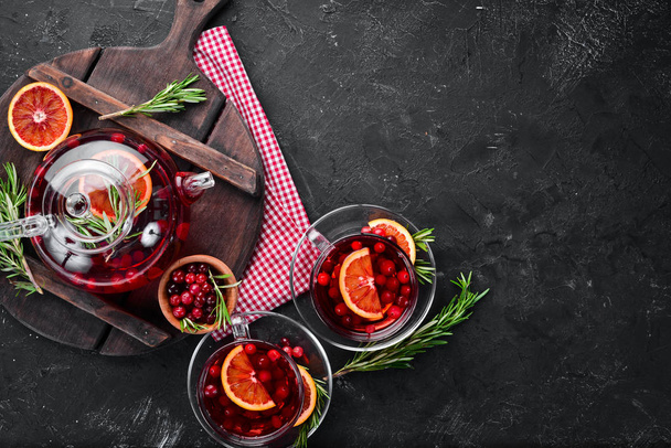Hot tea with berry cranberry and orange. On the black kitchen background. Top view. Free space for your text. - Foto, immagini