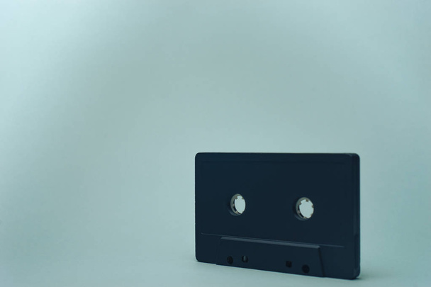 Black classic magnetic cassette tape on a gray background. - Foto, imagen