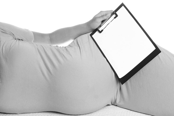 Happy pregnant girl lies on white background - Foto, afbeelding