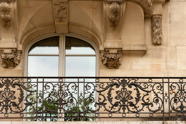 Window of one of the beautiful buildings along Champs Elysees avenue with typical wrought iron fences and modeling, Paris, France - Photo, Image