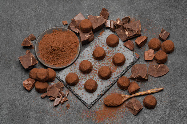 classic chocolate truffles and pieces of chocolate on dark concrete background - Фото, зображення