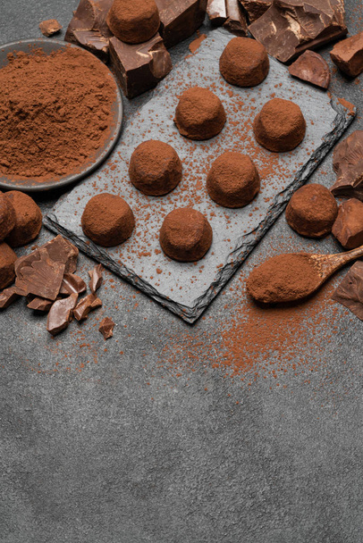 classic chocolate truffles and pieces of chocolate on dark concrete background - Фото, изображение