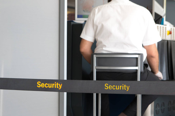 Mann scannt Gepäck an Sicherheitskontrolle am Flughafen - Foto, Bild