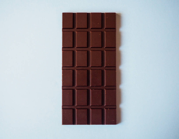 Une barre de chocolat isolée sur fond bleu de vue de dessus
 - Photo, image