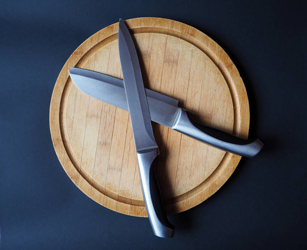 İki çapraz bıçak ile yuvarlak ahşap kesme tahtası - Fotoğraf, Görsel