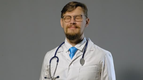 férfi orvos fehér kabátot szürke háttér, gyógyszer koncepció - Felvétel, videó