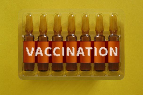 Conceito de vacinação. Sete ampolas com letras sobrepostas
 - Foto, Imagem