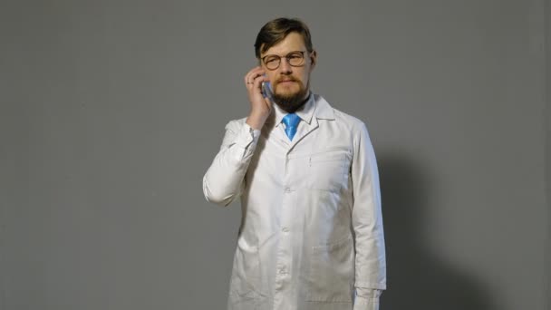 doctor man in white coat on gray background, medicine concept - Felvétel, videó