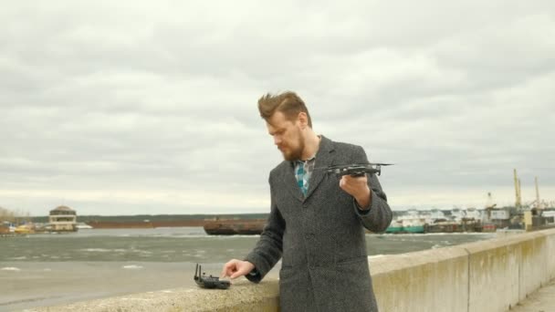 Mann steuert Quadrocopter im Freien - Filmmaterial, Video