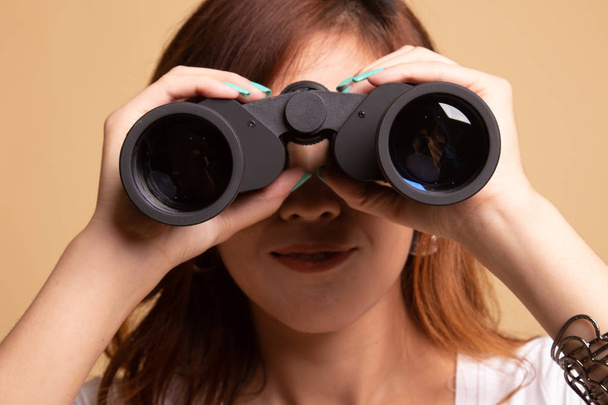 Young Asian woman with binoculars. - Фото, изображение
