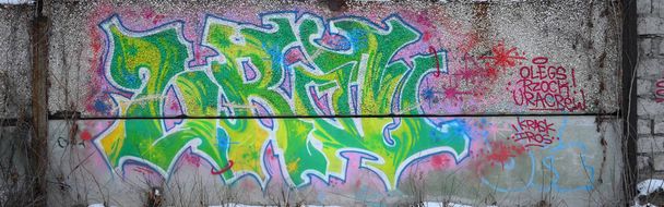 Θραύσμα από χρωματιστούς πίνακες γκράφιτι του δρόμου με καμπύλες και σκίαση. Φόντο της κουλτούρας της σύγχρονης τέχνης της νεολαίας. Πράσινα και κίτρινα χρώματα - Φωτογραφία, εικόνα