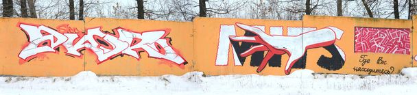 Fragment farbiger Street-Art-Graffiti-Gemälde mit Konturen und Schattierungen aus nächster Nähe. Hintergrund Textur der zeitgenössischen Jugendkultur. orange, rot und schwarz - Foto, Bild