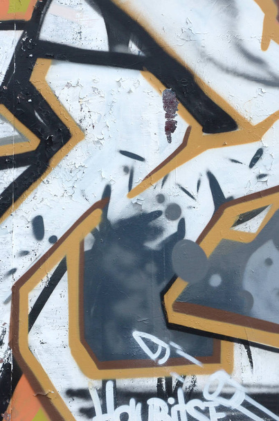 Θραύσμα από χρωματιστούς πίνακες γκράφιτι του δρόμου με καμπύλες και σκίαση. Φόντο της κουλτούρας της σύγχρονης τέχνης της νεολαίας. Γκρι και πορτοκαλί χρώματα - Φωτογραφία, εικόνα