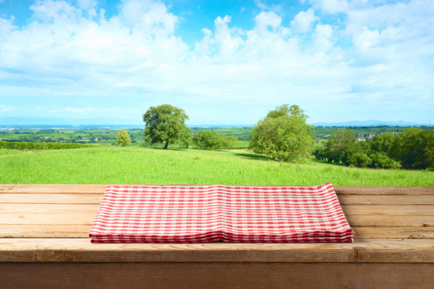 Yaz çayır arka planda masa örtüsü ile boş ahşap masa - Fotoğraf, Görsel