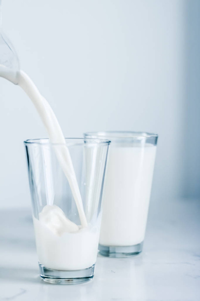 Světový den mléka, nalévání do skla na mramorovém stole - Fotografie, Obrázek