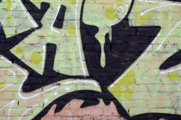 Θραύσμα από χρωματιστούς πίνακες γκράφιτι του δρόμου με καμπύλες και σκίαση. Φόντο της κουλτούρας της σύγχρονης τέχνης της νεολαίας. Πράσινα κίτρινα χρώματα - Φωτογραφία, εικόνα