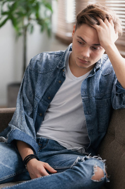 Sad teenage student sitting alone at home waiting for his father - Valokuva, kuva