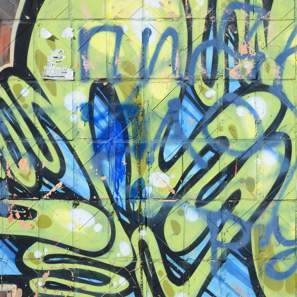 Fragment van gekleurde straatkunst graffiti schilderijen met contouren en arcering close-up. Achtergrond textuur van de jeugd hedendaagse kunst cultuur. Groen geel kleuren - Foto, afbeelding